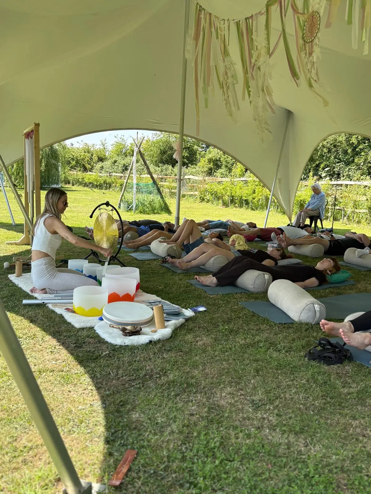 Sound bath under the stretch tent with crystal bowls and gong